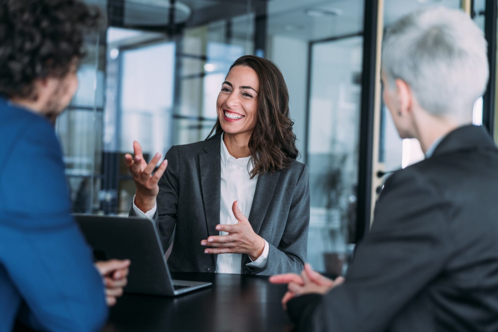 Business meeting with three people discussing.